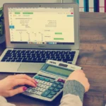 Small business owner reviewing a weekly cash flow forecast spreadsheet on a laptop