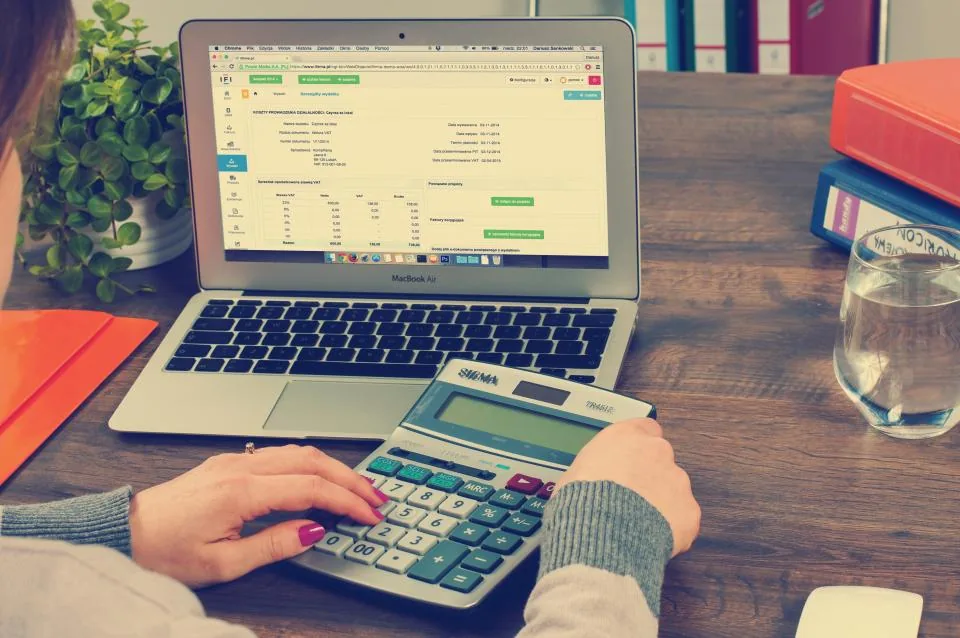 Small business owner reviewing a weekly cash flow forecast spreadsheet on a laptop
