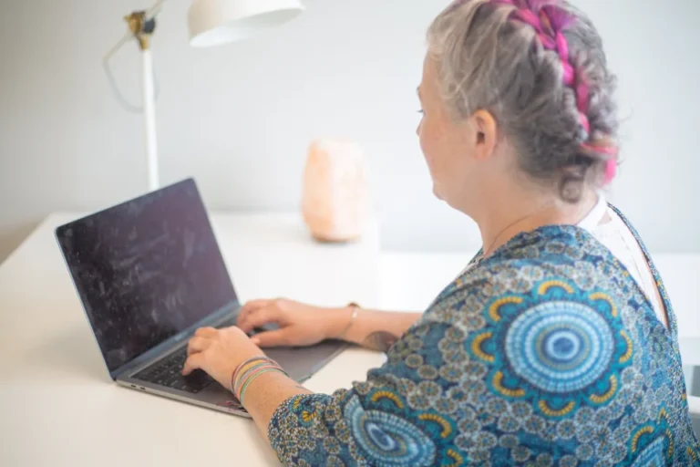 Professional typing a clear, concise email on a laptop at a modern office desk