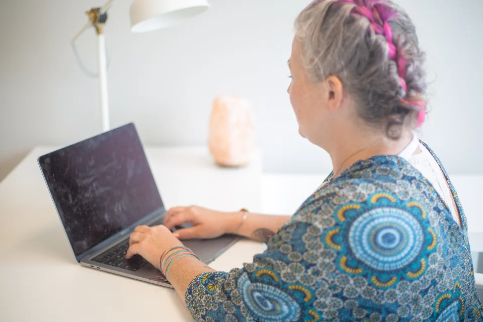 Professional typing a clear, concise email on a laptop at a modern office desk